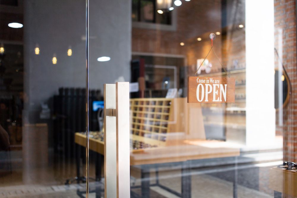 A glass door with a sign that says open on it.