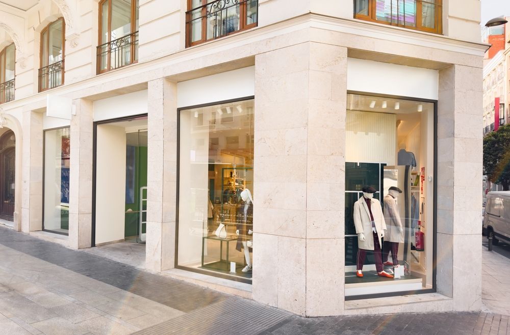 A store front with a lot of windows and mannequins in the window.