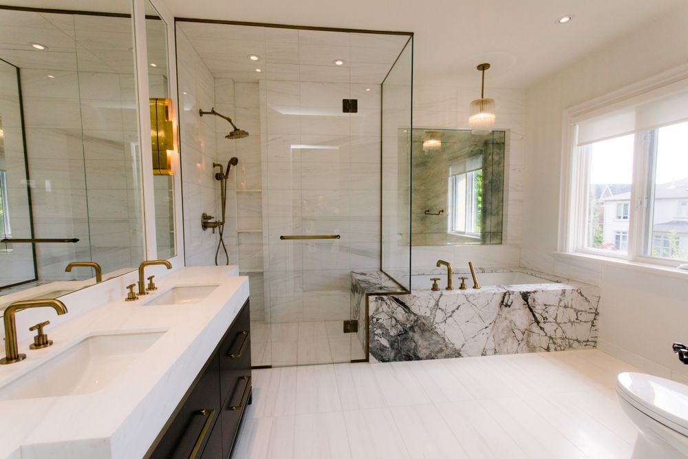 A bathroom with two sinks , a toilet , and a walk in shower.