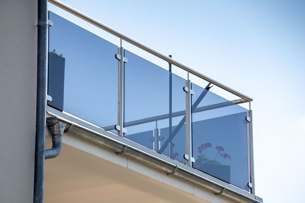 A balcony with a glass railing on the side of a building.