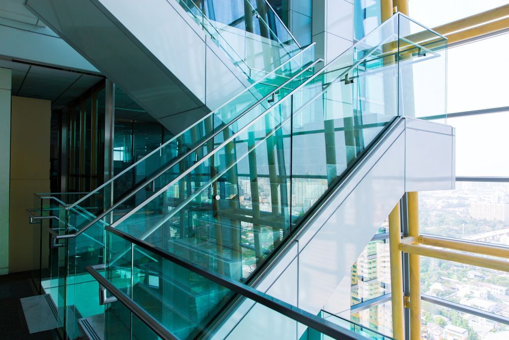 A glass staircase in a building with a view of the city