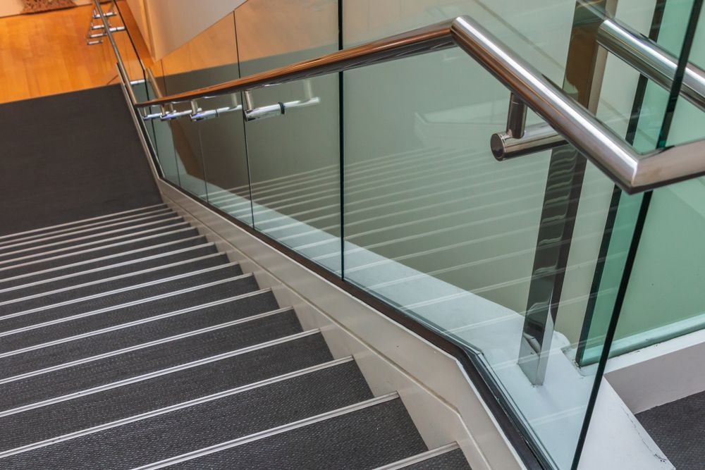 A staircase with a glass railing and carpeted steps