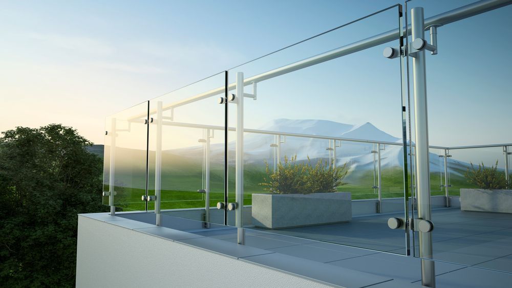 A balcony with a glass railing and a mountain in the background.