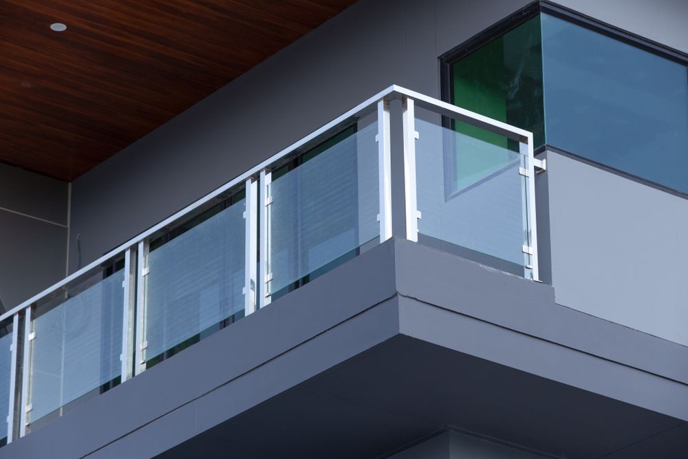 A balcony with a glass railing on the side of a building
