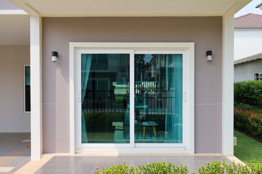 A house with a sliding glass door leading to a patio.
