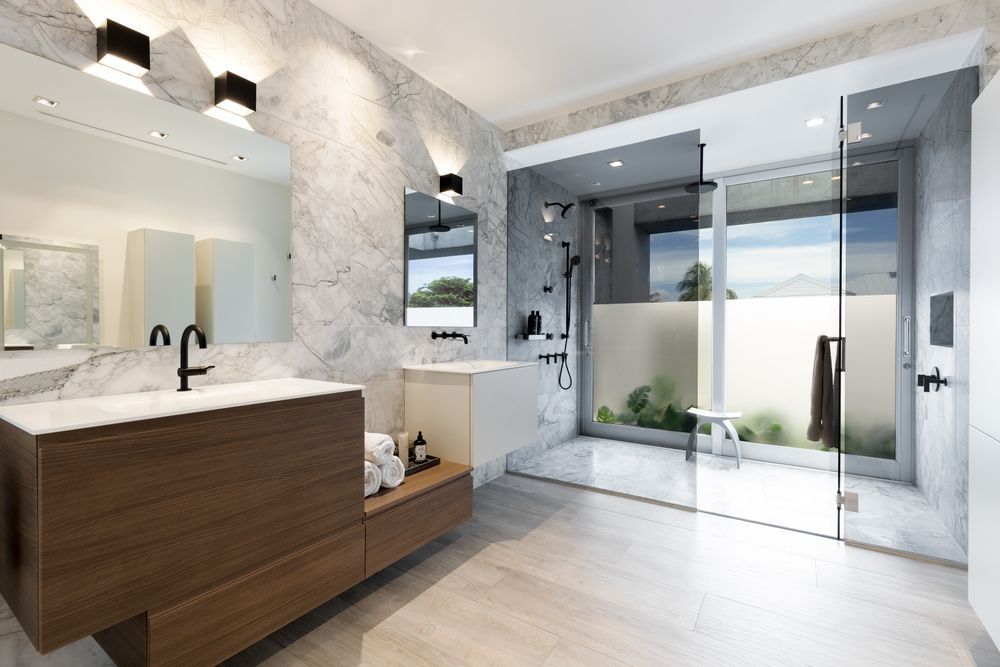 A bathroom with two sinks and a walk in shower