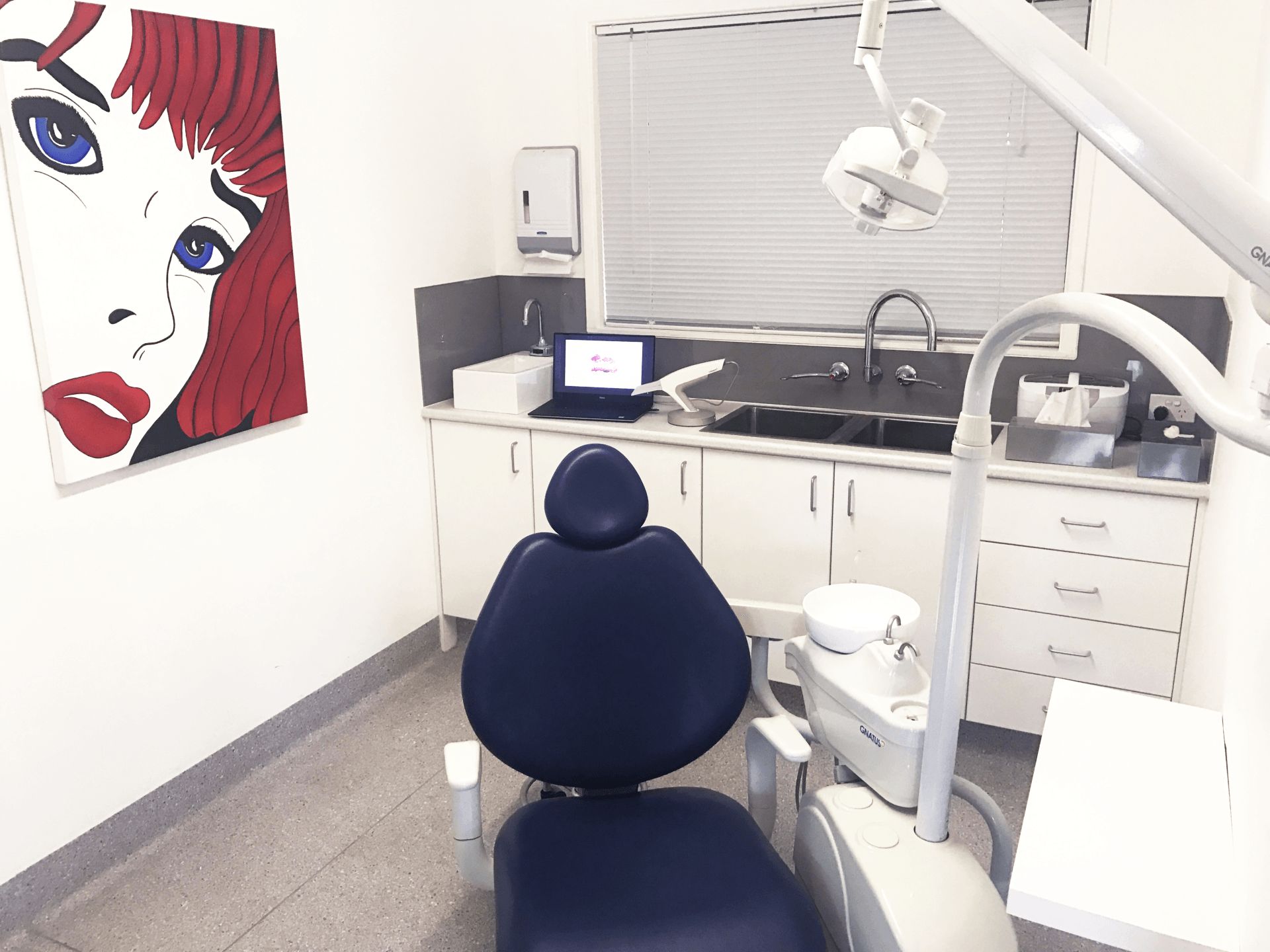 A dental office with a painting of a woman on the wall