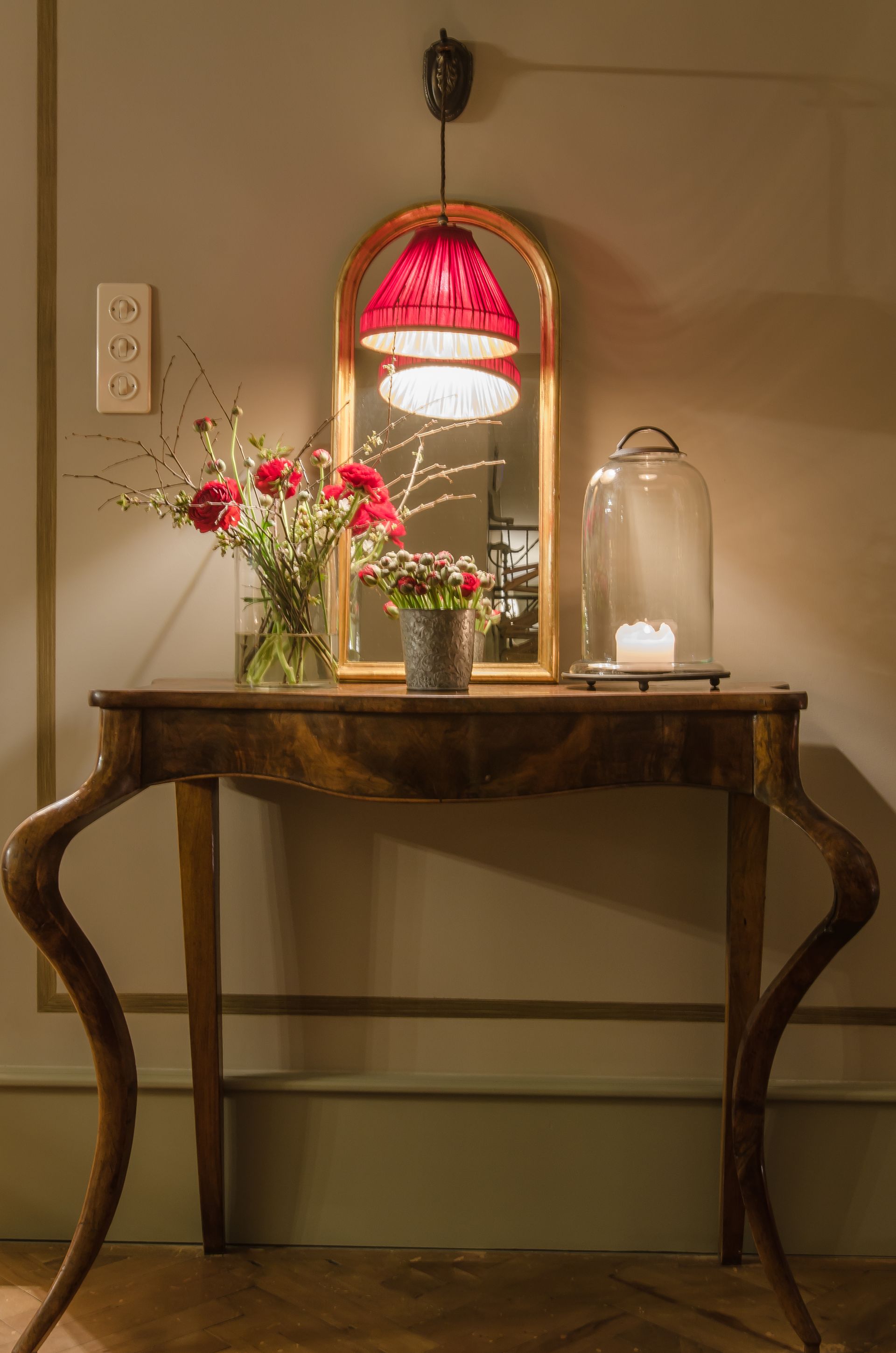 une table en bois avec un vase de fleurs et un miroir .
