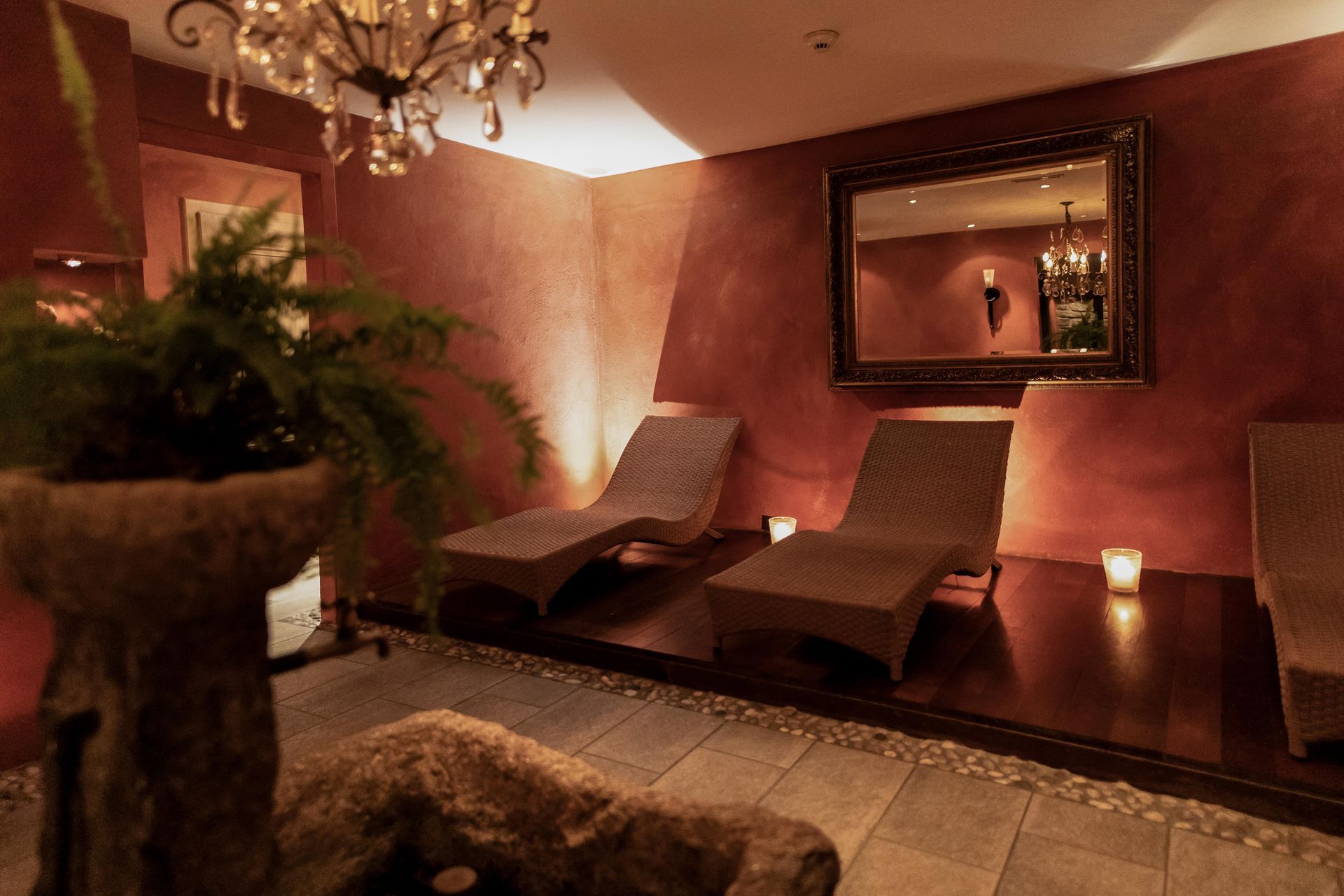 un salon avec des chaises longues et un miroir.