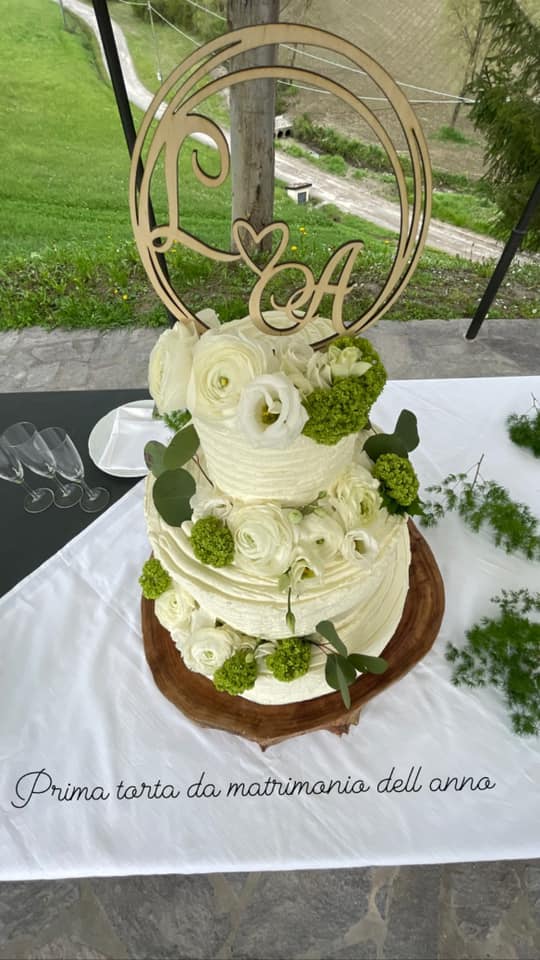 torta nuziale con iniziali degli sposi e rose bianche