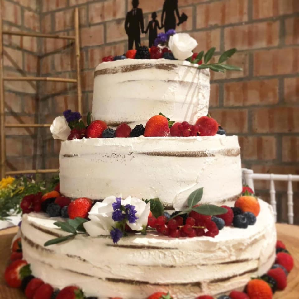 torta nuziale ai frutti di bosco con famiglia in cima