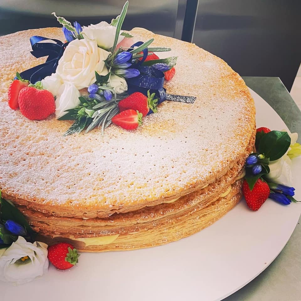 torta millefoglie con crema, fiori e frutti di bosco