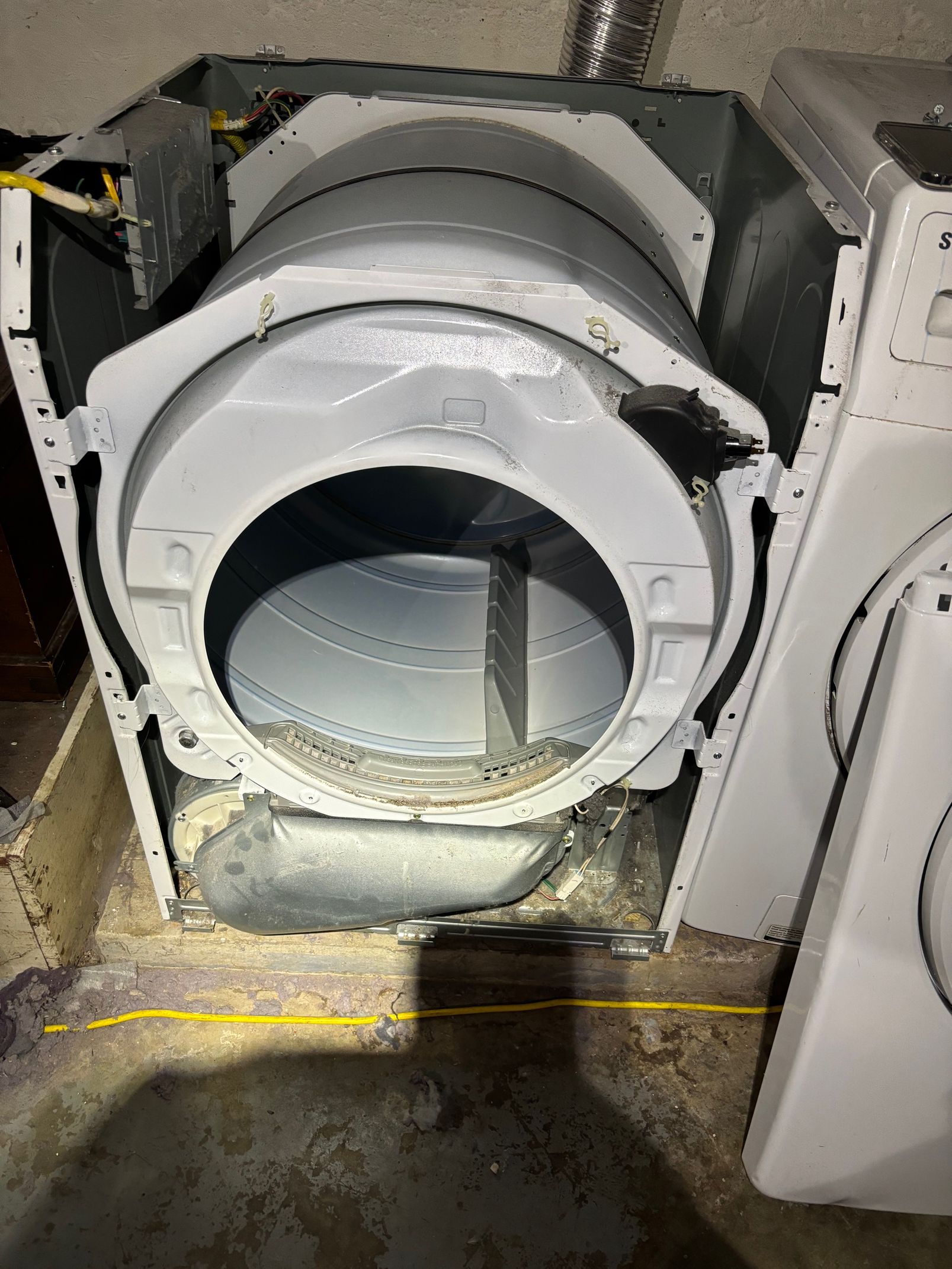 Open dryer interior, showing the drum and exposed components. Gray, white, and silver.