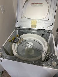 Open washing machine; laundry basket inside; skewers resting on the rim.