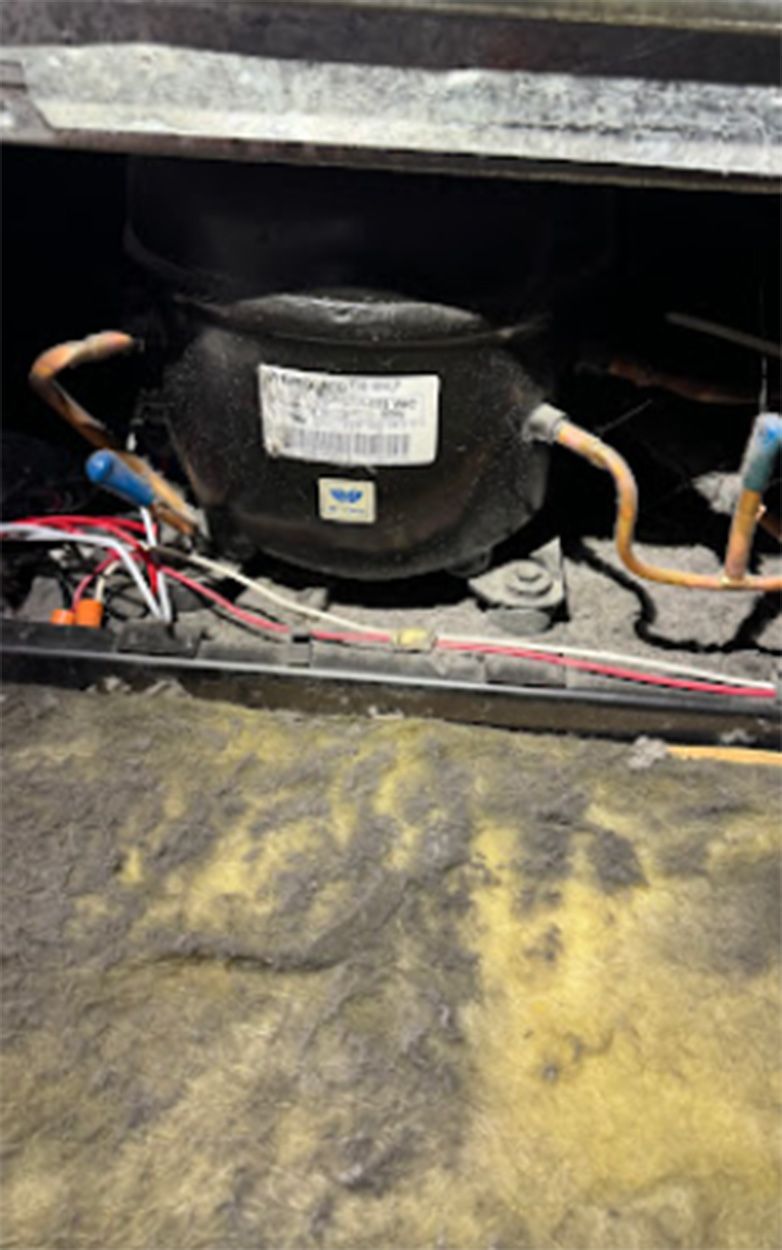 Refrigerator compressor with copper tubing and wiring.