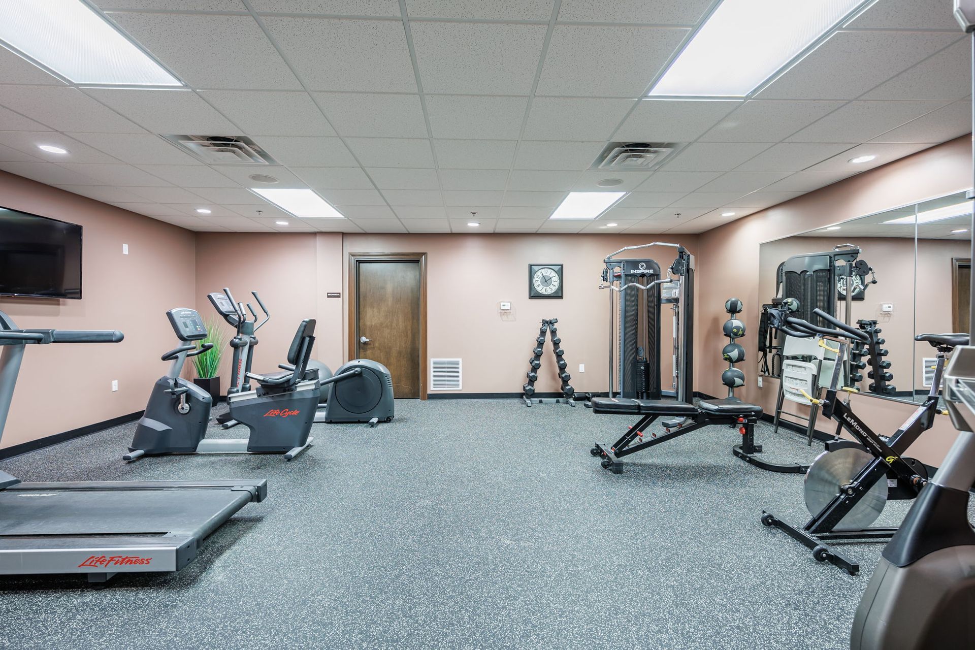 Gym with treadmill, eliptical, bikes, cable machine, and weights