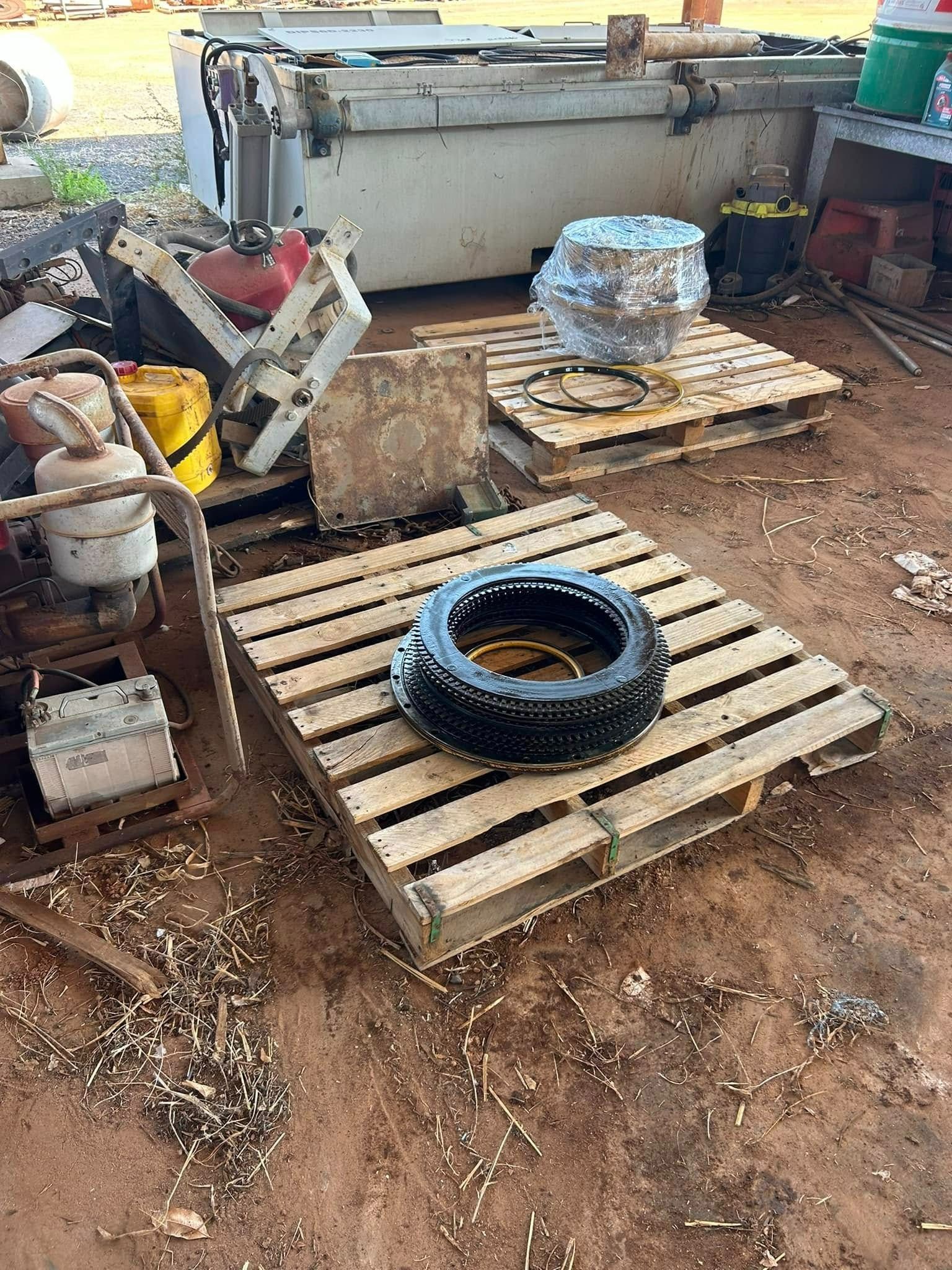 Tyre, engine parts, and metal scraps on wooden pallets in an outdoor, industrial setting — Full Noise Mechanical in Humpty Doo, NT