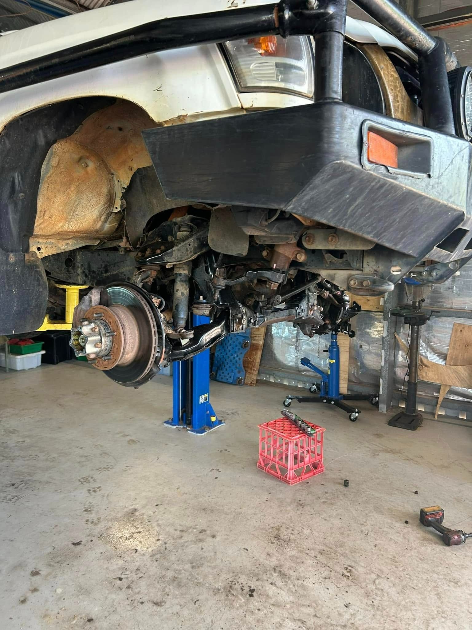 Front End of A White Off-Road Vehicle Raised on A Lift for Repairs — Full Noise Mechanical in Humpty Doo, NT