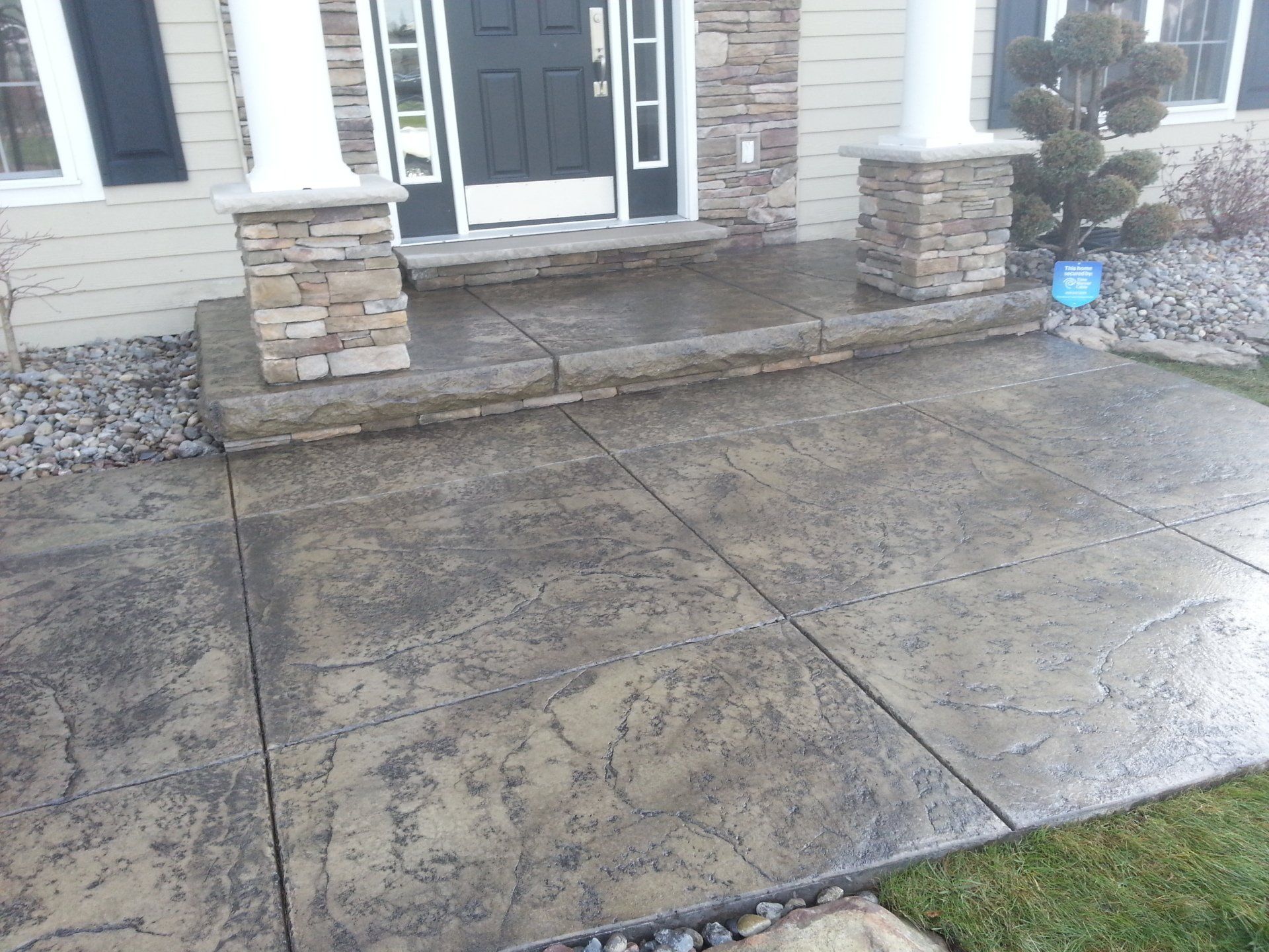 A concrete walkway leading to the front door of a house