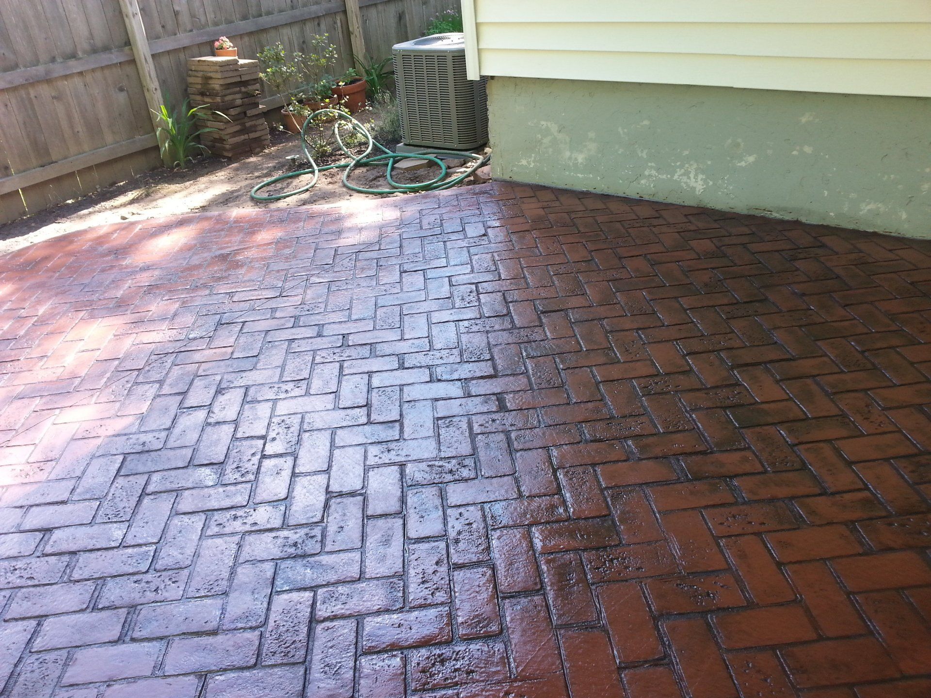 A before and after picture of a brick patio being cleaned.
