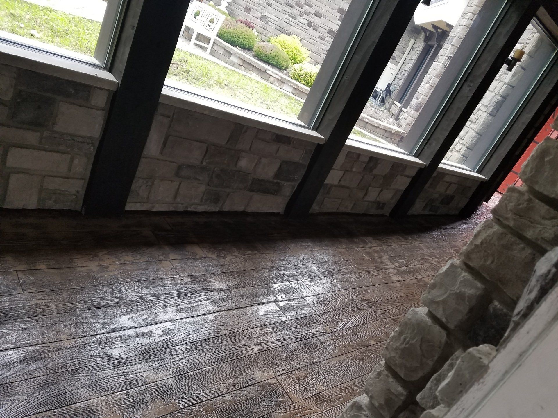 A room with a lot of windows and a brick wall.