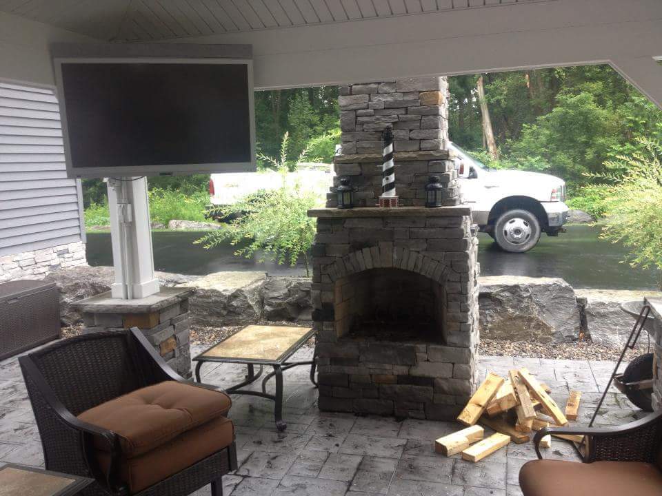 A patio with a fireplace and a flat screen tv