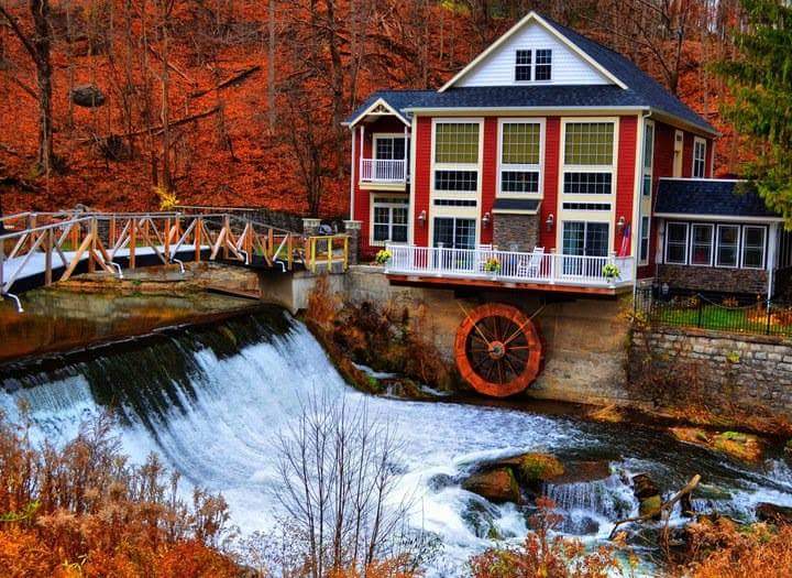 A house with a water wheel on the side of it