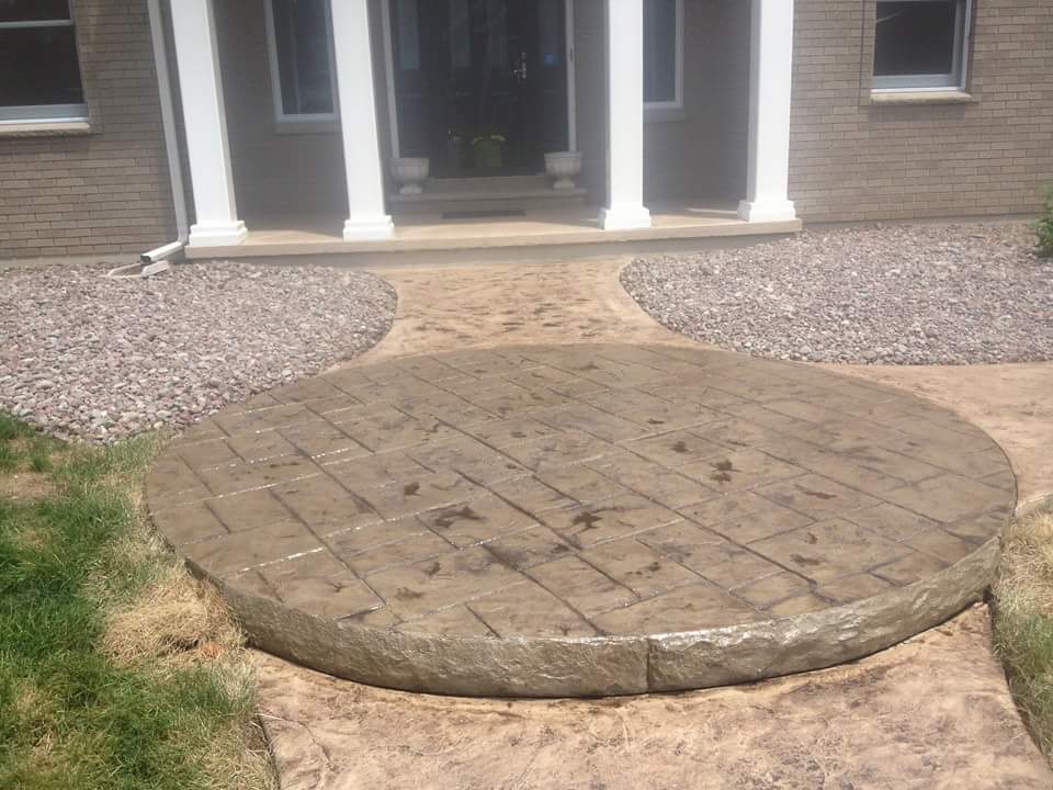 A circular concrete walkway in front of a house