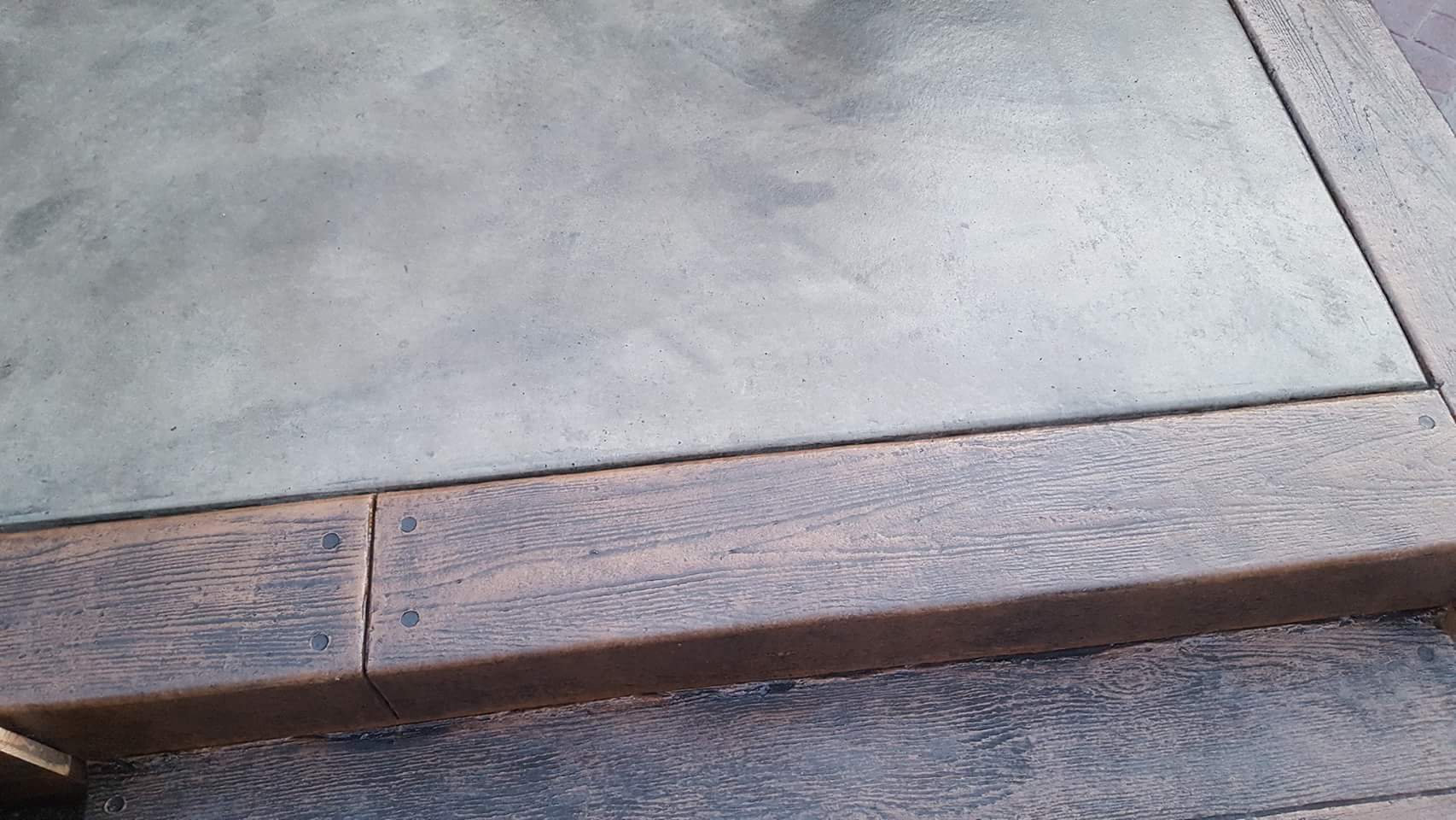 A close up of a concrete floor with a wooden border.