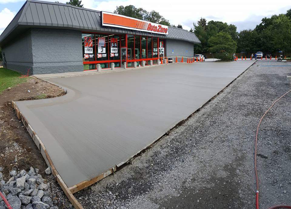 A concrete driveway is being built in front of a store