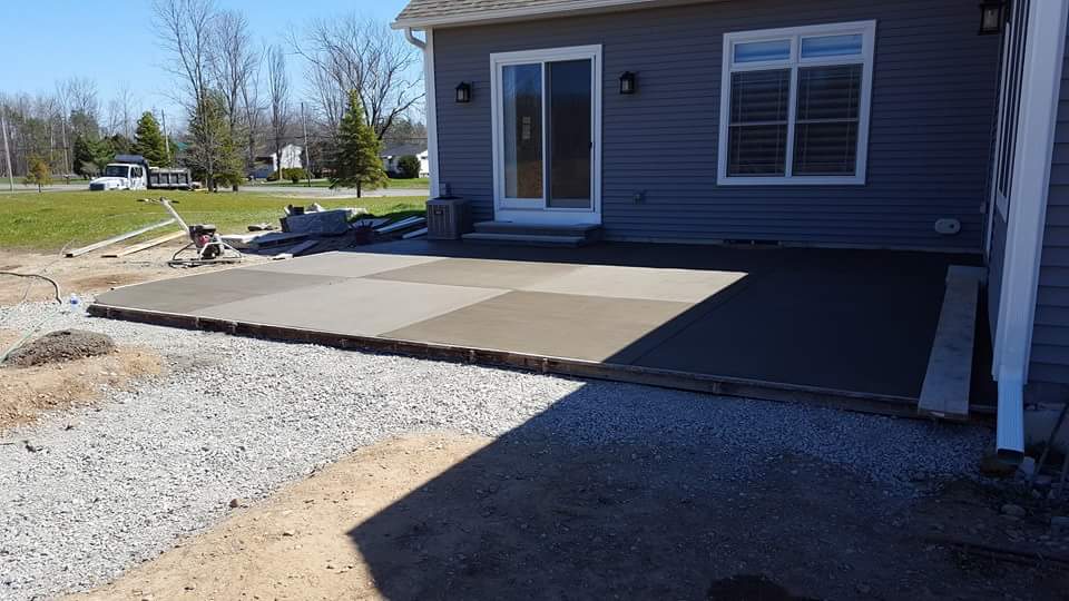 A concrete patio is being built in front of a house.