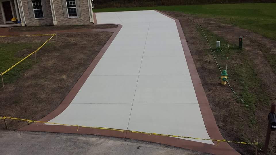 An aerial view of a concrete driveway leading to a house.