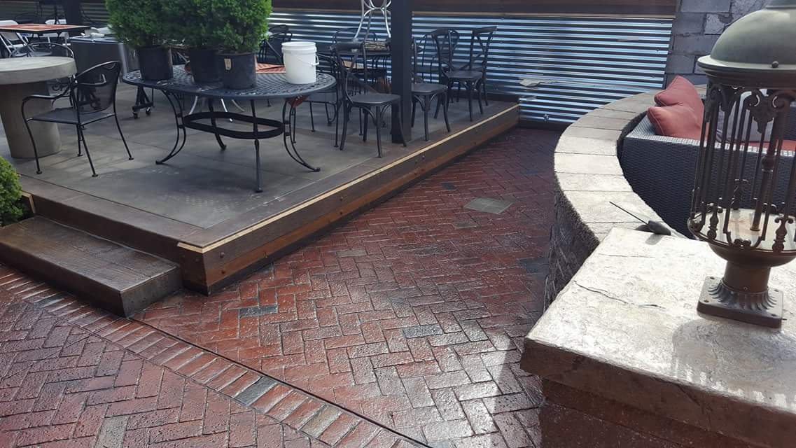 A patio with tables and chairs and a fire pit