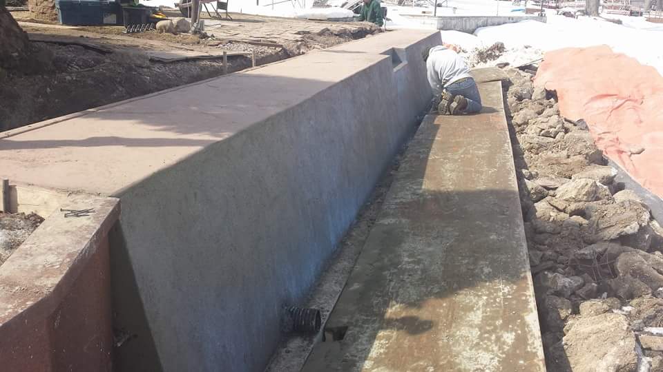 A concrete wall is being built in a park.