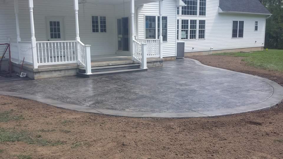 A white house with a concrete patio in front of it.