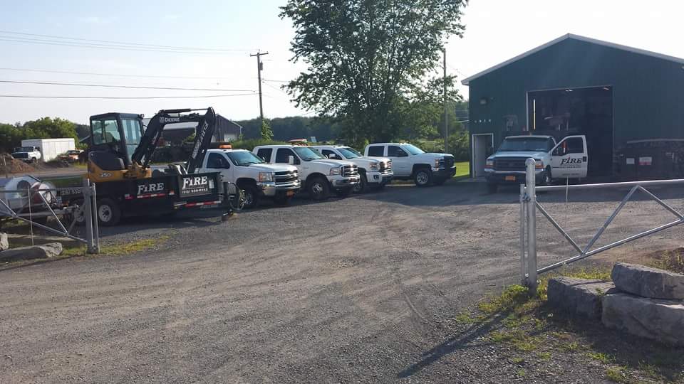 A row of trucks are parked in front of a building.