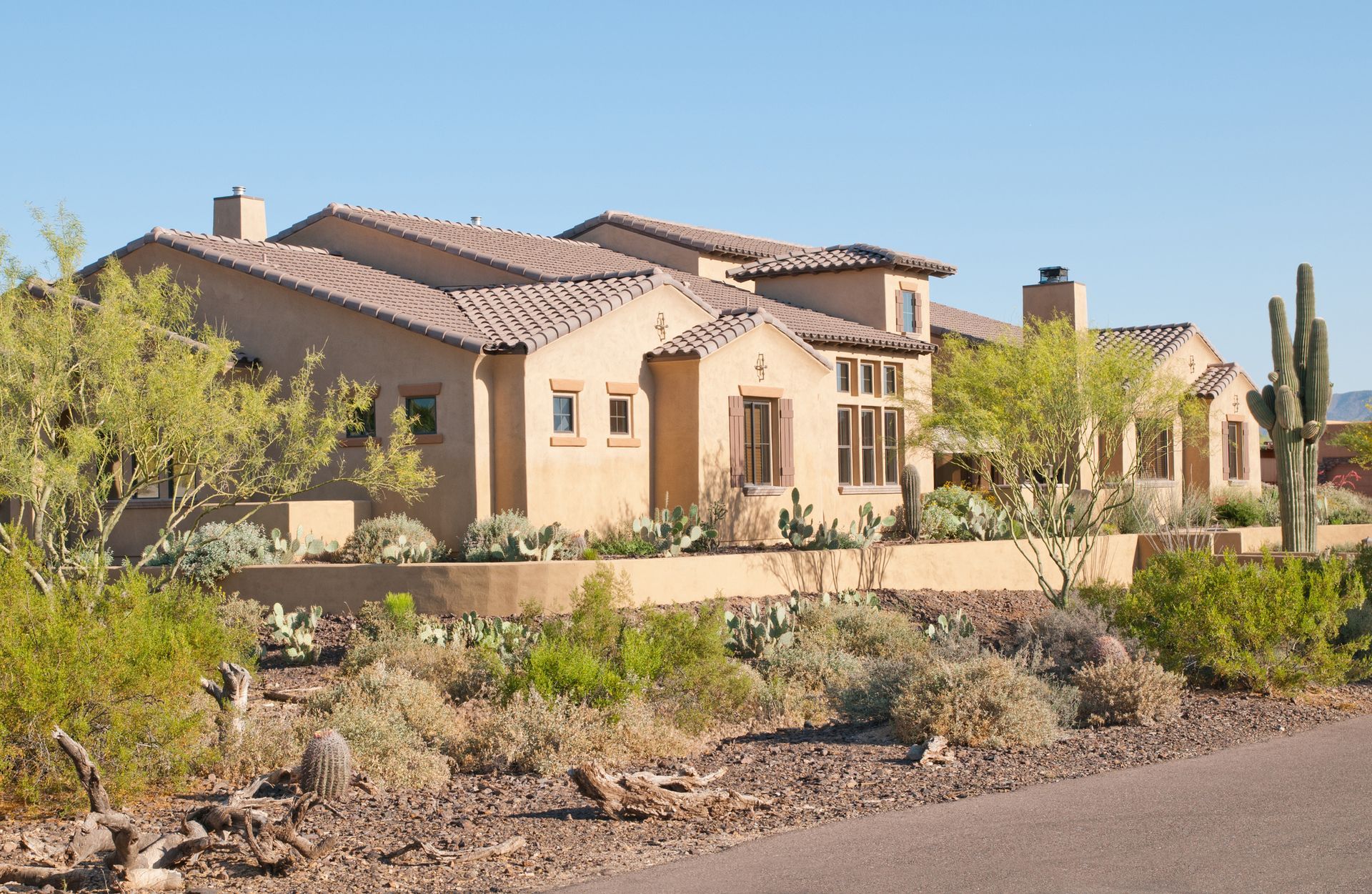 Two Construction Workers Are Working On The Roof With Sunset Behind — Bullhead City, AZ — Nailed It Better Roofing