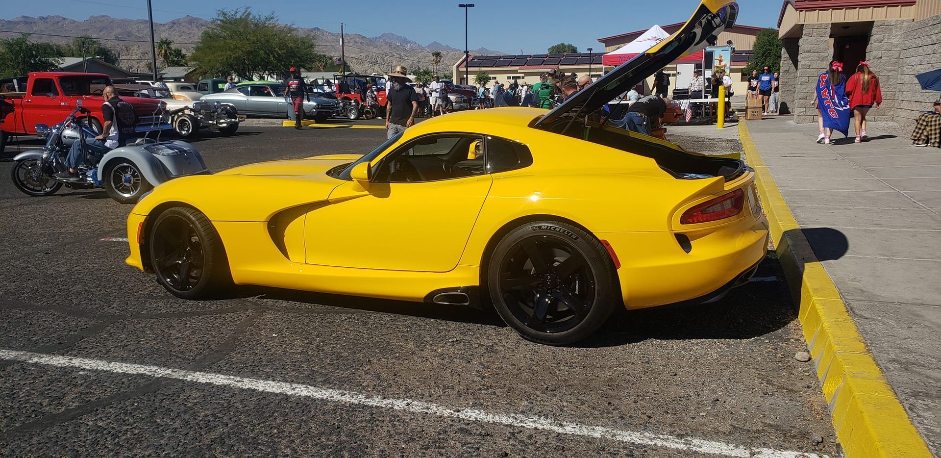 a yellow sports car is parked in a parking lot .