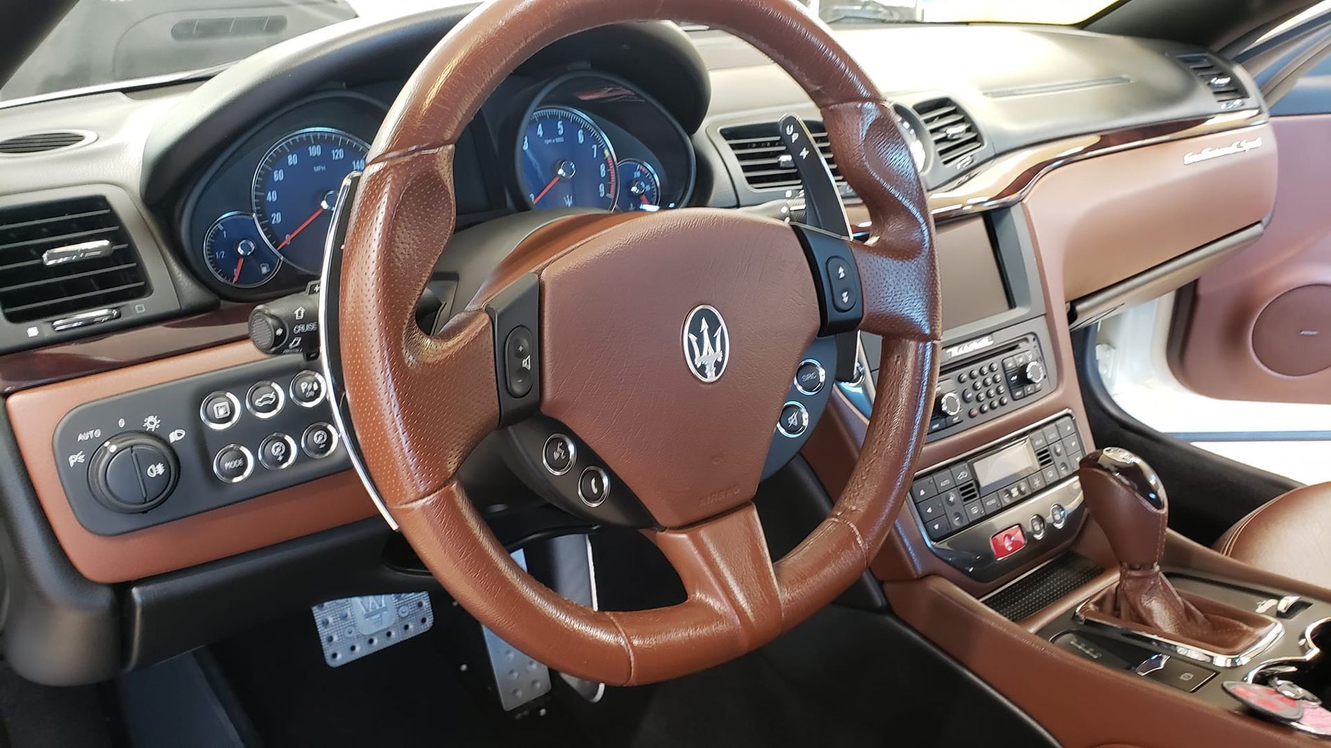 the interior of a maserati car with a brown steering wheel