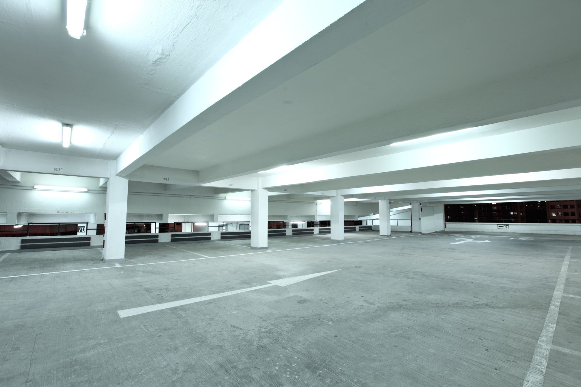 A large commercial parking lot under a building