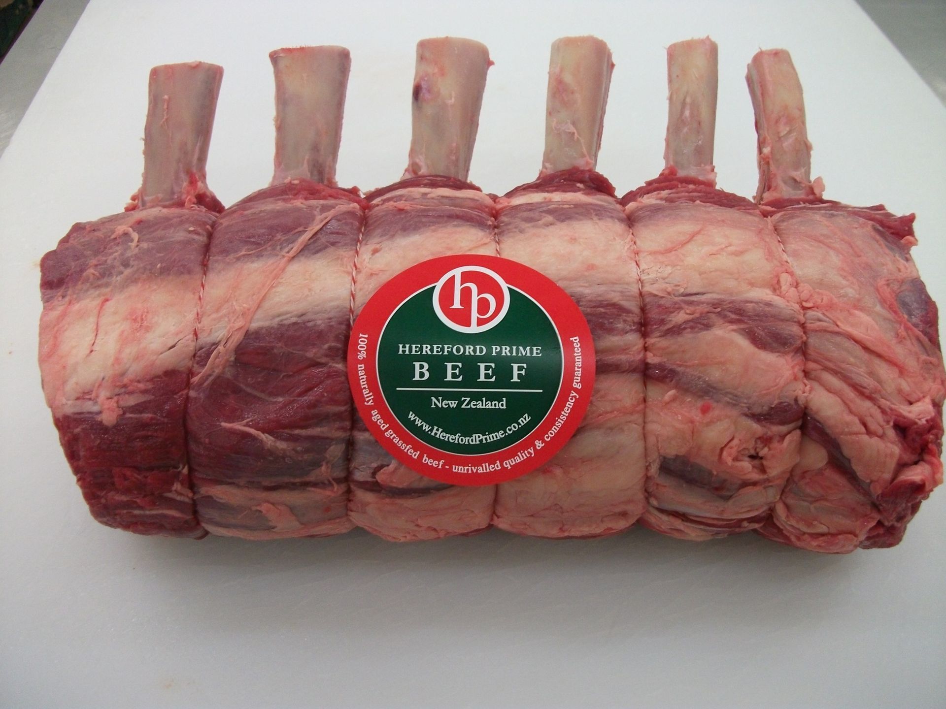 A tied roast of beef with bones sticking out, labeled