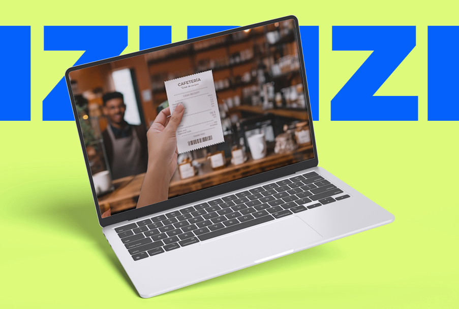 Una persona sostiene un recibo frente a una computadora portátil.