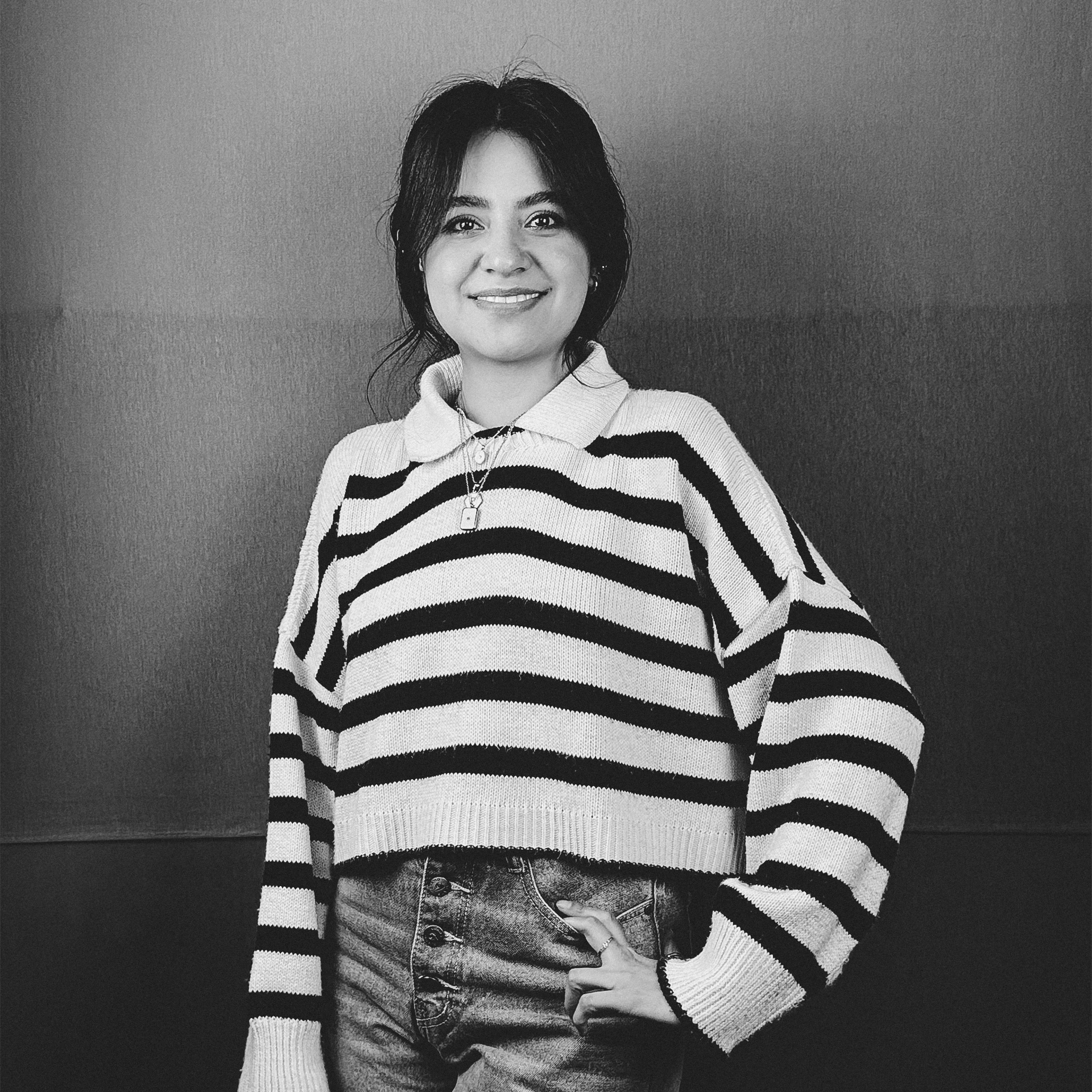 Una fotografía en blanco y negro de una mujer que lleva un suéter de rayas.