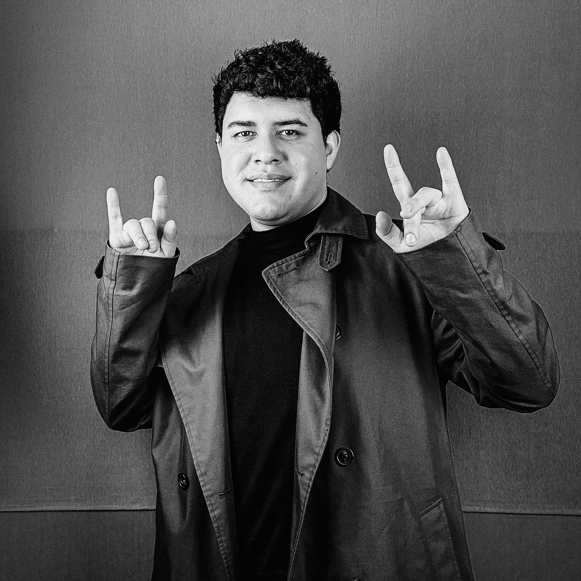 Una fotografía en blanco y negro de un hombre haciendo una señal con cuernos.