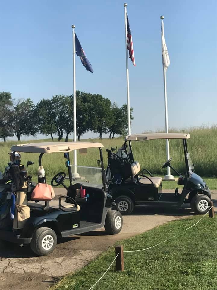 Golf carts in front of flags