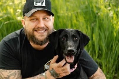 a smiling man and a dog