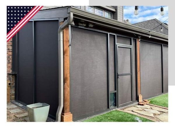 A brown screen room attached to a brick house with a covered grill on the concrete pad. American flag graphic in the top left corner.