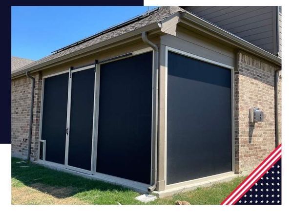 Black outdoor retractable screens on a brick patio, offering sun protection.