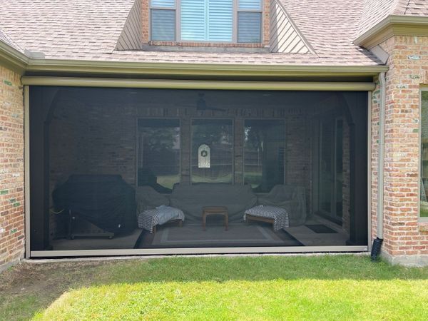 Poolside structure with dark garage doors open. Contains a pool, patio furniture, and basketball hoop.