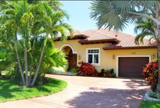 Windows — Yellow House with Wood Doors in Deerfield Beach, FL